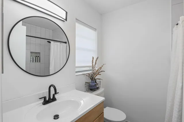 a bathroom with a bathtub shower sink and toilet