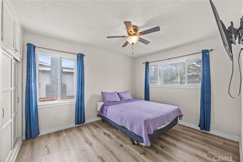 10028 Primrose Drive Riverside, CA 92503 - Photo 12 of 19 a bedroom with a bed and wooden floor