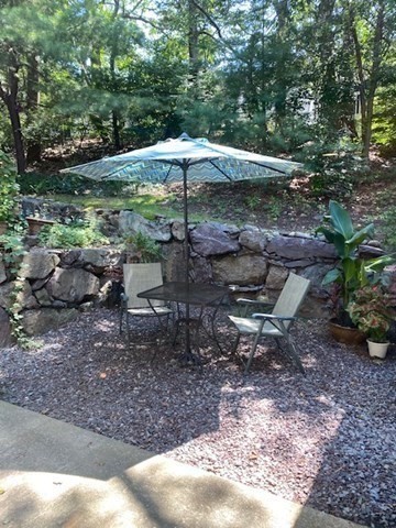 10 Beal's Cove Road, Unit E Hingham, MA 02043 - Photo 4 of 10 a view of a table and chairs under an umbrella