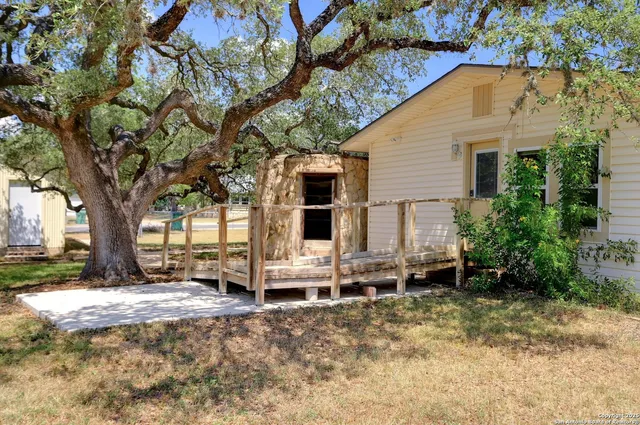 a view of a house with backyard and trees