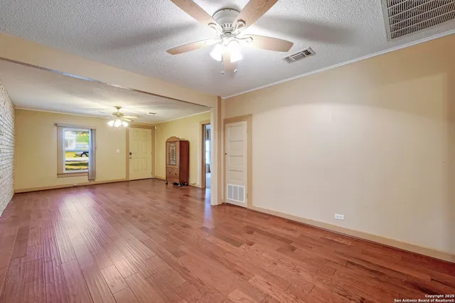 a view of a livingroom with wooden floor and a ceiling fan
