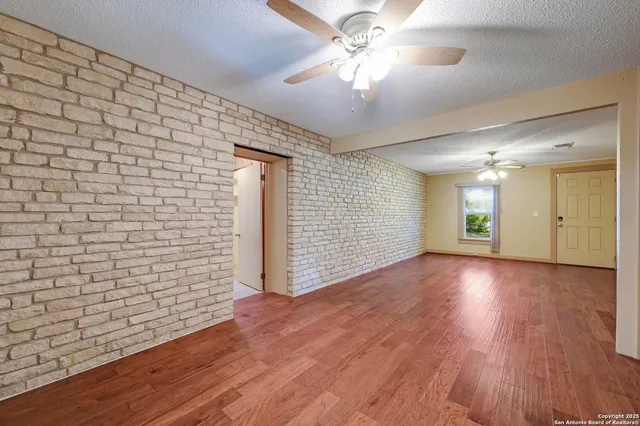 a view of a livingroom with wooden floor and a ceiling fan