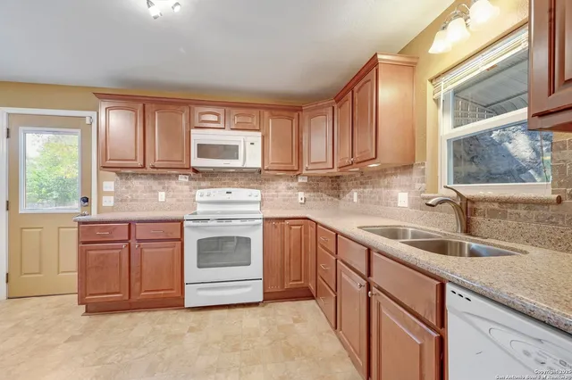 a kitchen with granite countertop a sink stainless steel appliances and cabinets