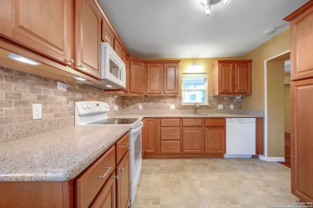 a kitchen with granite countertop a sink stainless steel appliances and cabinets