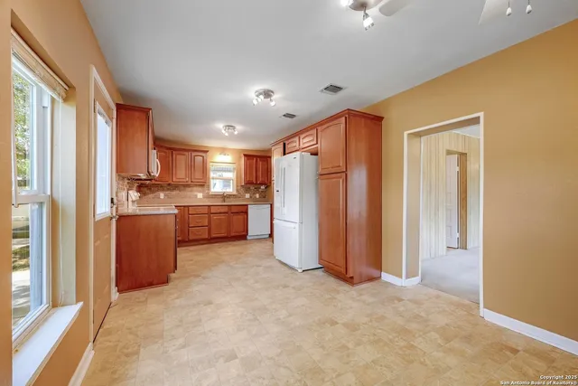 a view of a kitchen with refrigerator and a sink