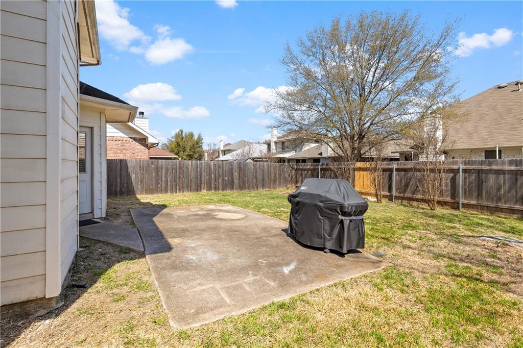 3508 Bratton Ridge Crossing Austin, TX 78728 - Photo 18 of 18 A modest patio and verdant lawn offer private outdoor relaxation behind a wooden privacy fence.