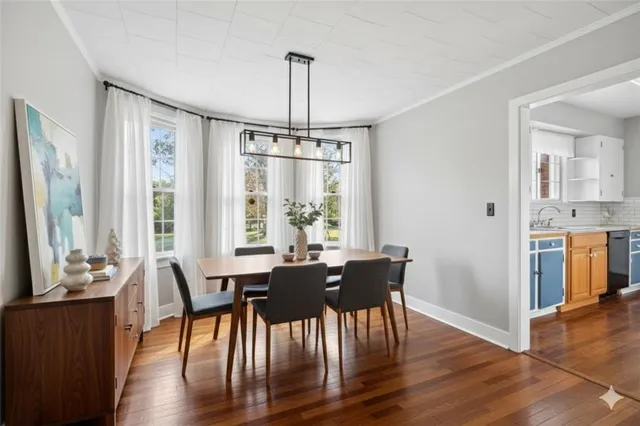 a view of a a dining room with furniture window and wooden floor