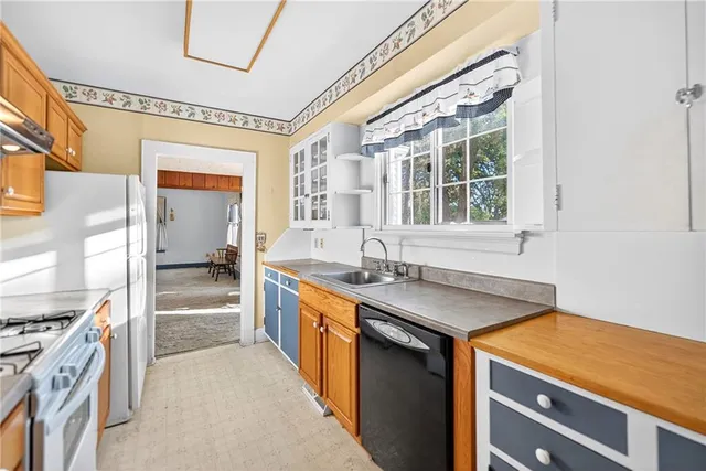 a utility room with stainless steel appliances granite countertop a sink and a stove
