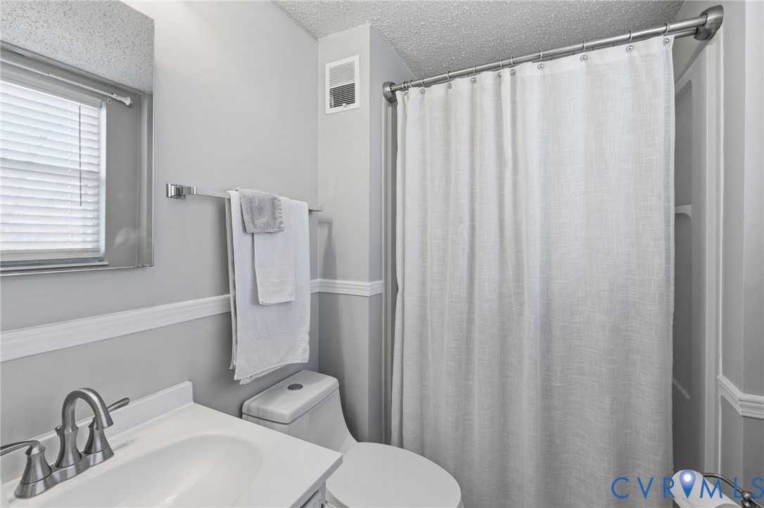 9643 Snowhill Road Richmond, VA 23235 - Photo 17 of 30 a bathroom with a sink a toilet and a mirror