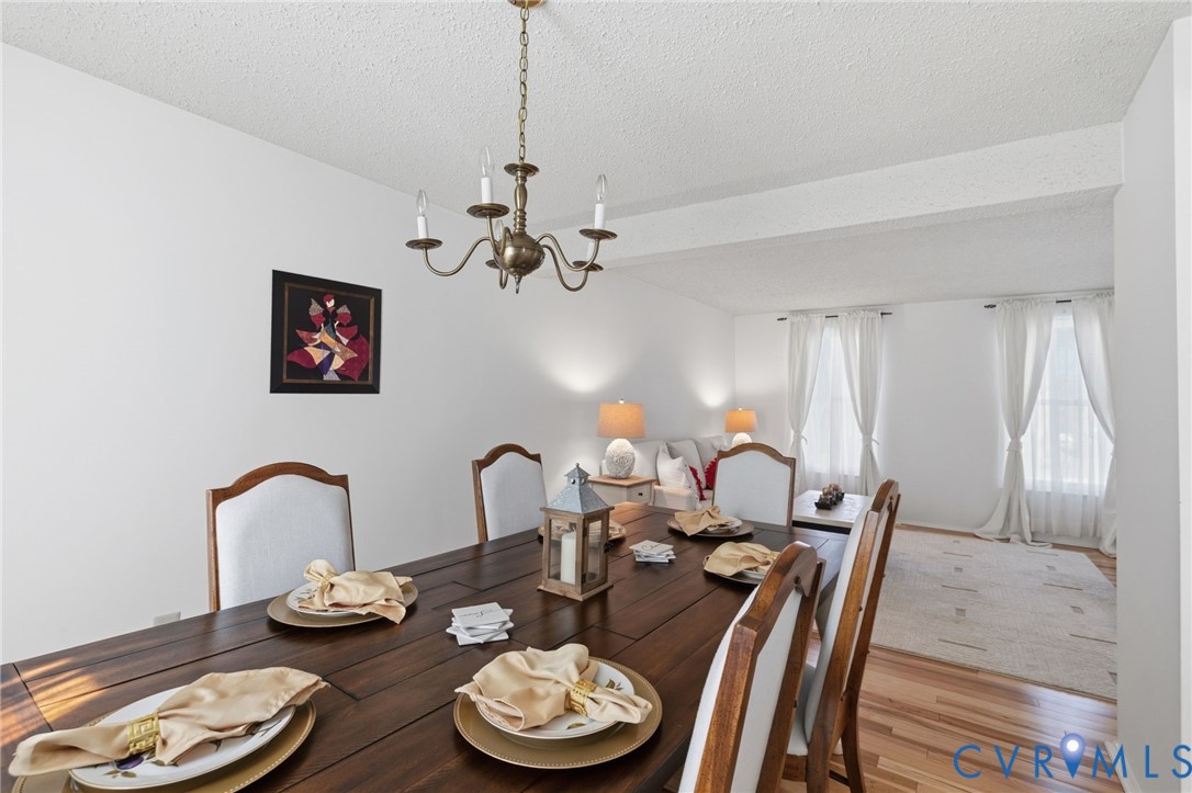 9643 Snowhill Road Richmond, VA 23235 - Photo 7 of 30 a dining room with furniture and a chandelier