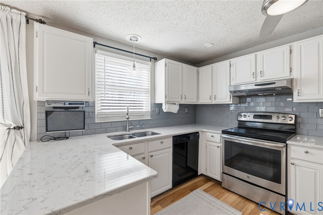 9643 Snowhill Road Richmond, VA 23235 - Photo 9 of 30 a kitchen with granite countertop a stove sink and cabinets