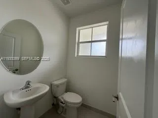 a bathroom with a sink toilet and a mirror