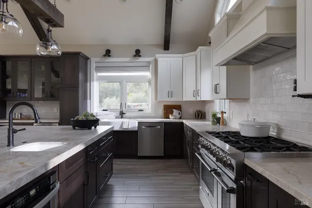 a kitchen with stainless steel appliances a sink stove and cabinets