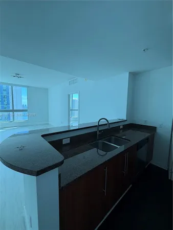 a view of an empty room with window and ceiling fan