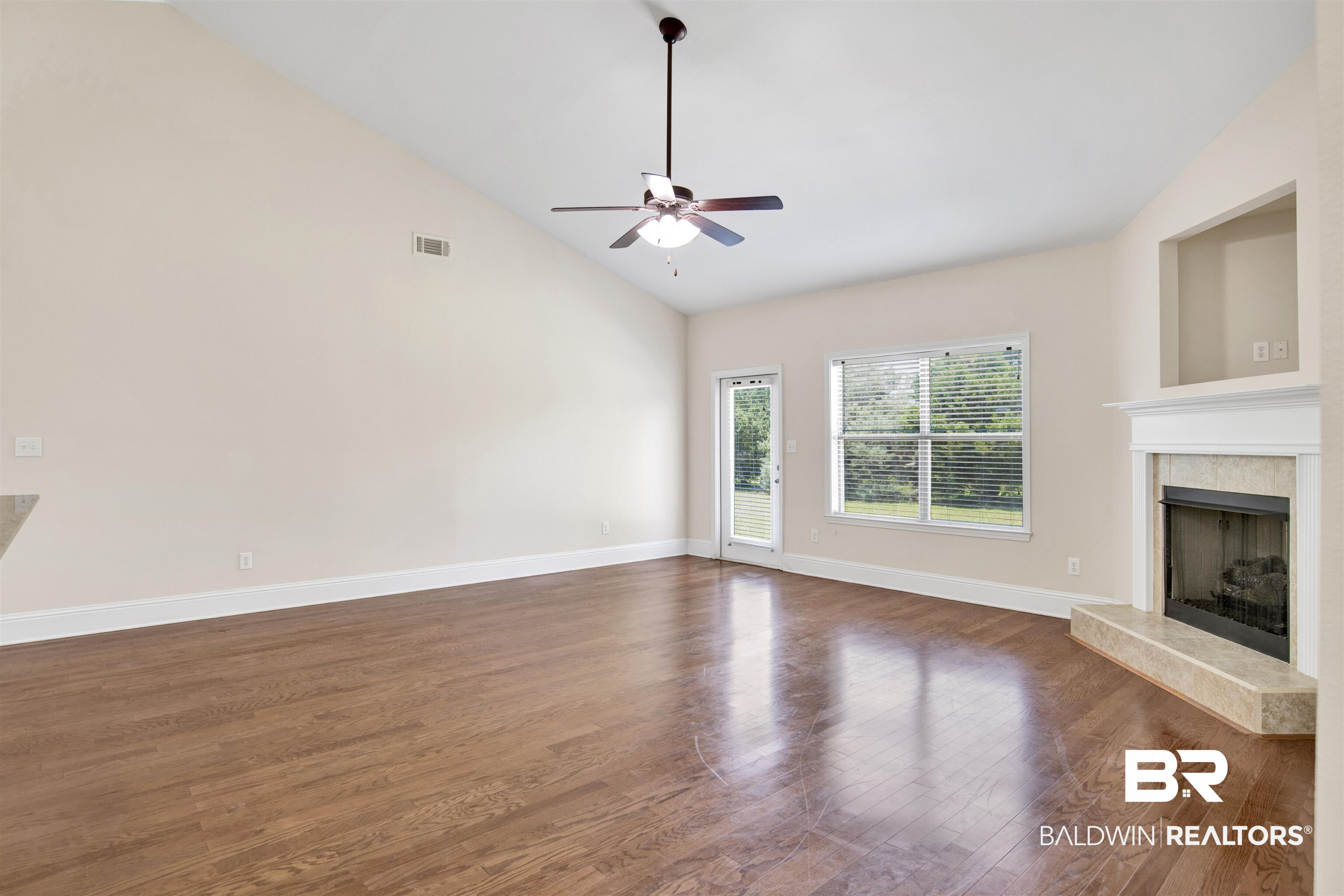 10910 Roanoke Loop Daphne, AL 36526 - Photo 11 of 33 Unfurnished living room with visible vents, baseboards, dark wood-type flooring, ceiling fan, and a high end fireplace