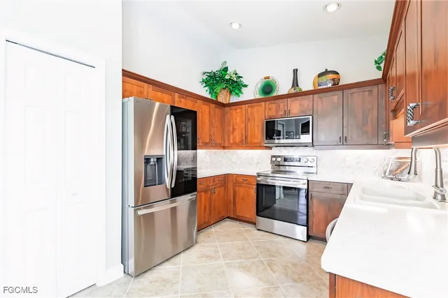 a kitchen with stainless steel appliances granite countertop a refrigerator and a stove top oven