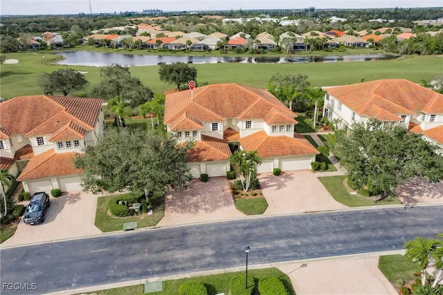 an aerial view of a house with garden space and lake view in back