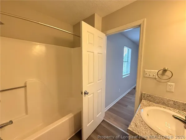 a bathroom with a granite countertop bathtub shower and sink