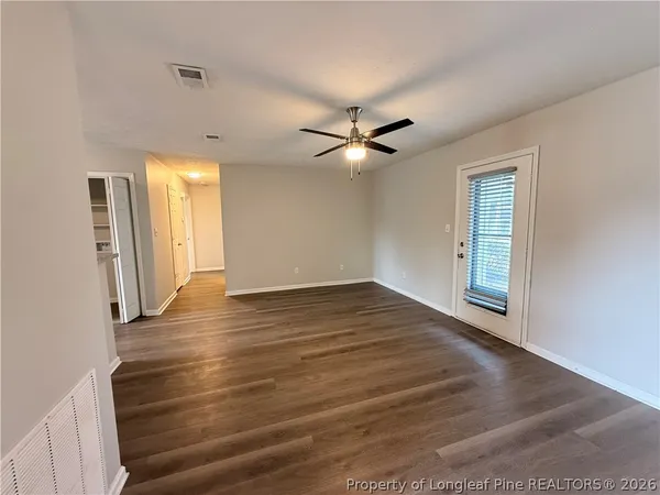 a view of a livingroom with wooden floor and a ceiling fan