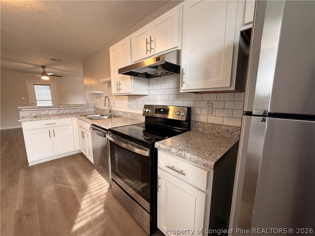 4924 Cameron Road Hope Mills, NC 28348 - Photo 4 of 13 a kitchen with stainless steel appliances granite countertop a sink a stove and cabinets
