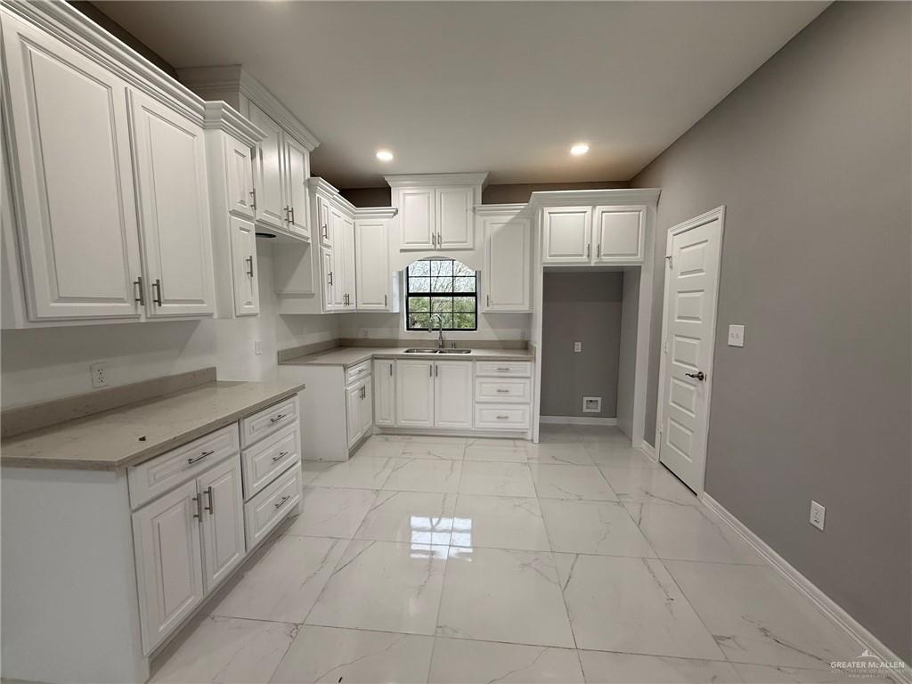 4195 Chapotito Street Rio Grande City, TX 78582 - Photo 3 of 15 a large white kitchen with stainless steel appliances granite countertop a sink and cabinets
