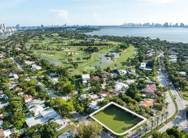 an aerial view of residential houses with outdoor space and trees