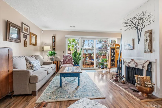 a living room with furniture large window and wooden floor