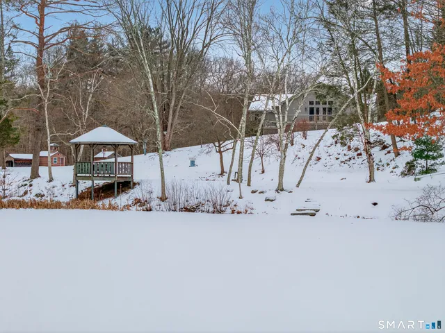a front view of a house with a yard covered with snow