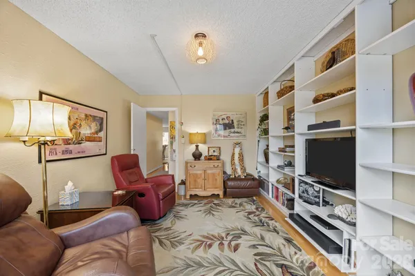 a living room with furniture cabinets and a window