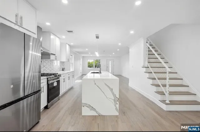 a kitchen with stainless steel appliances kitchen island sink stove and refrigerator