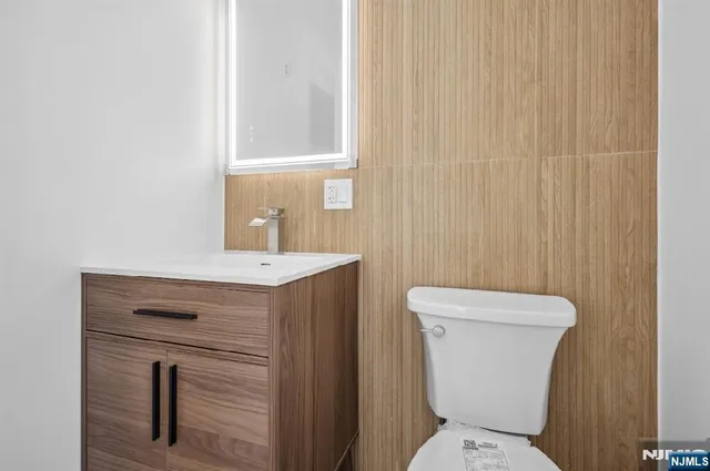 a bathroom with a toilet a sink and mirror