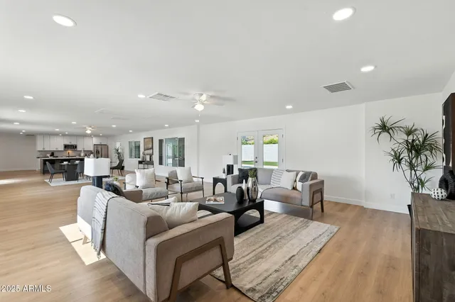 a living room with furniture ceiling fan and a window