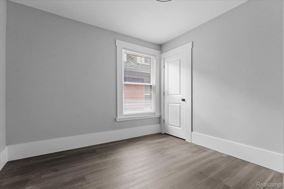 58 East Philadelphia Street Detroit, MI 48202 - Photo 16 of 24 Room featuring wood-finish flooring, light gray wall paint, and white trim
