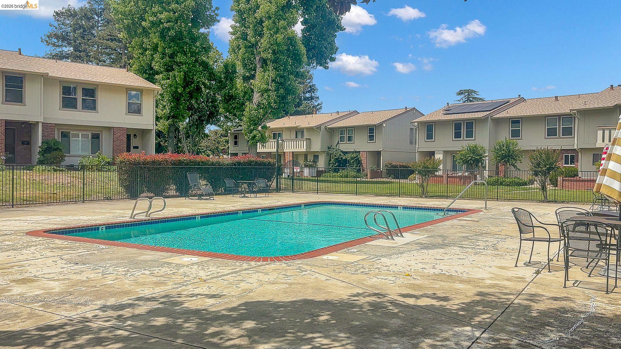 1808 Wildbrook Court, Unit D Concord, CA 94521 - Photo 46 of 47 a view of a house with swimming pool and a yard