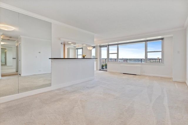 an empty room with kitchen and window