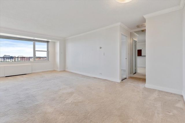 an empty room with chandelier fan and windows