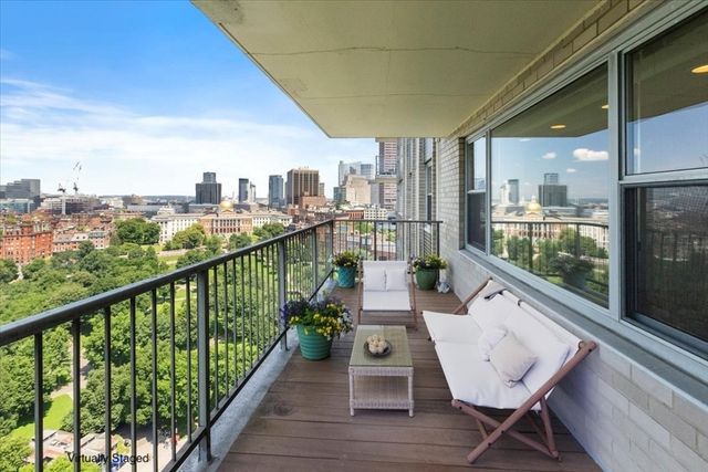 a view of a city from a balcony with furniture