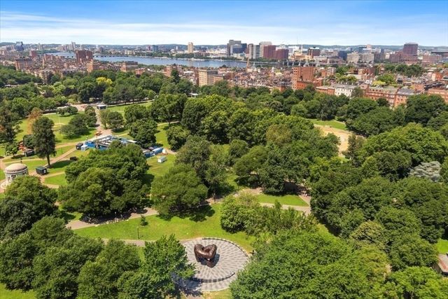 an aerial view of residential houses with outdoor space and trees