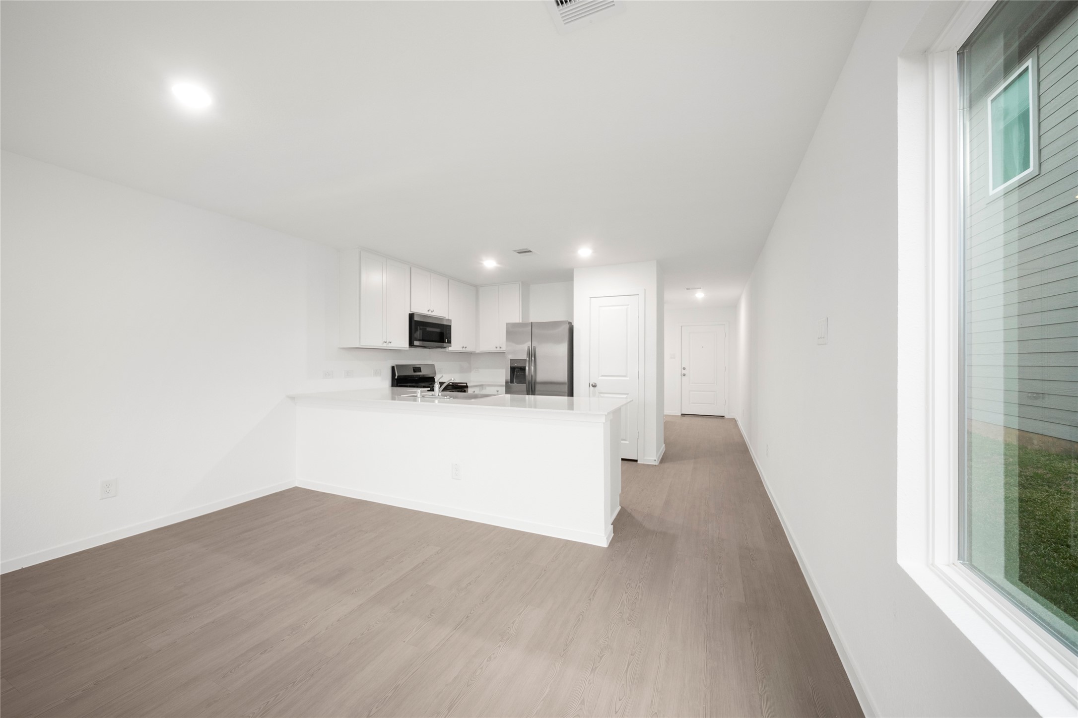 31436 Moore Road Magnolia, TX 77354 - Photo 7 of 25 a view of kitchen with kitchen island a sink wooden floor and a refrigerator