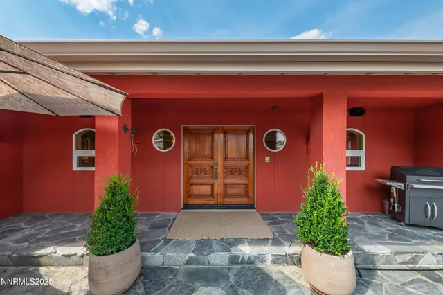 a front view of a house with potted plants