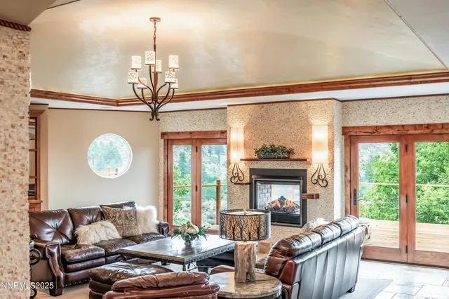 a living room with furniture a fireplace and a floor to ceiling window