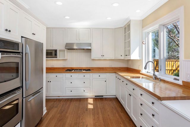 a kitchen with granite countertop cabinets stainless steel appliances a sink and a large window