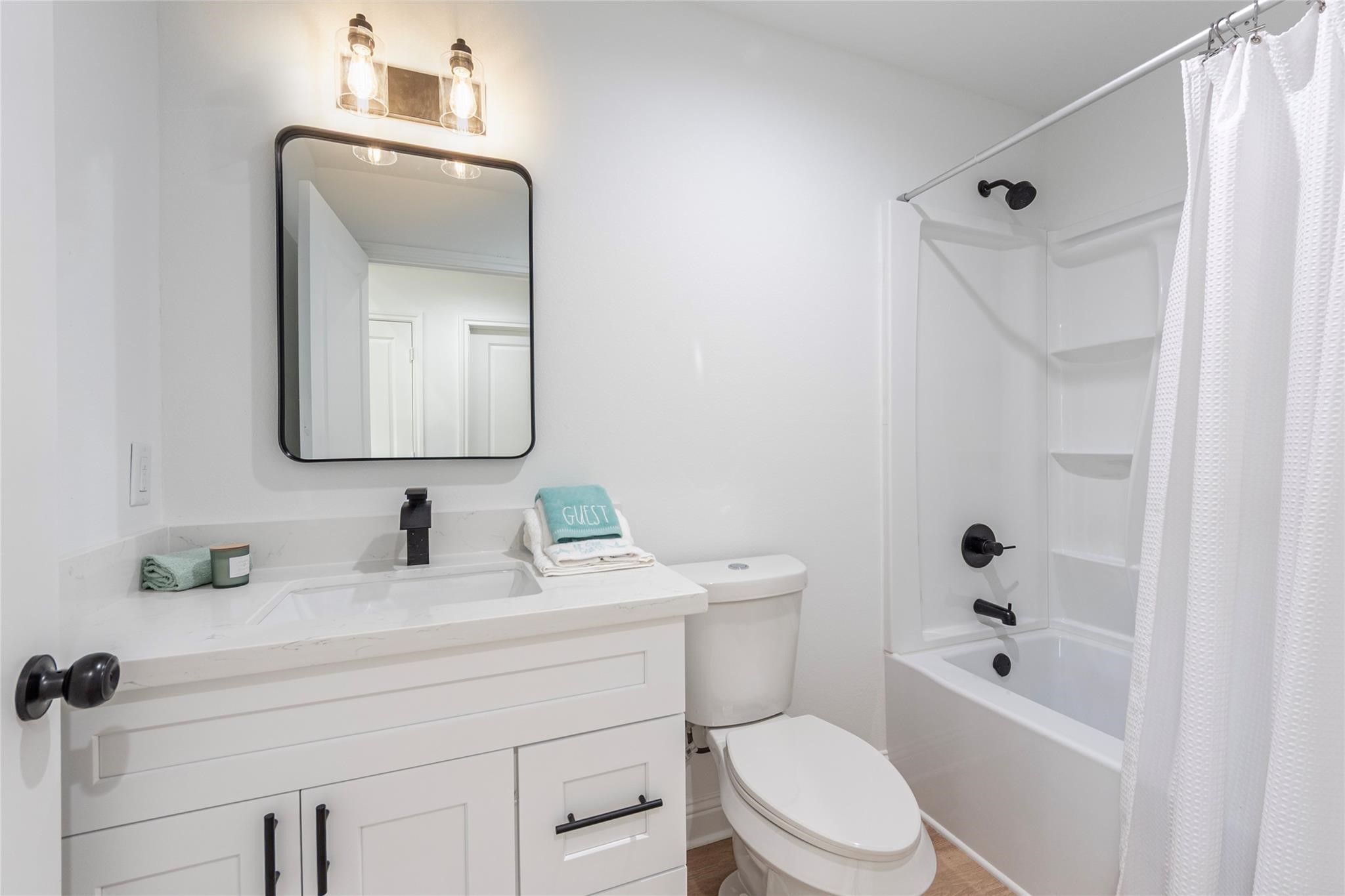 4213 Houx Street Bacliff, TX 77518 - Photo 18 of 37 a bathroom with a toilet sink a shower and mirror