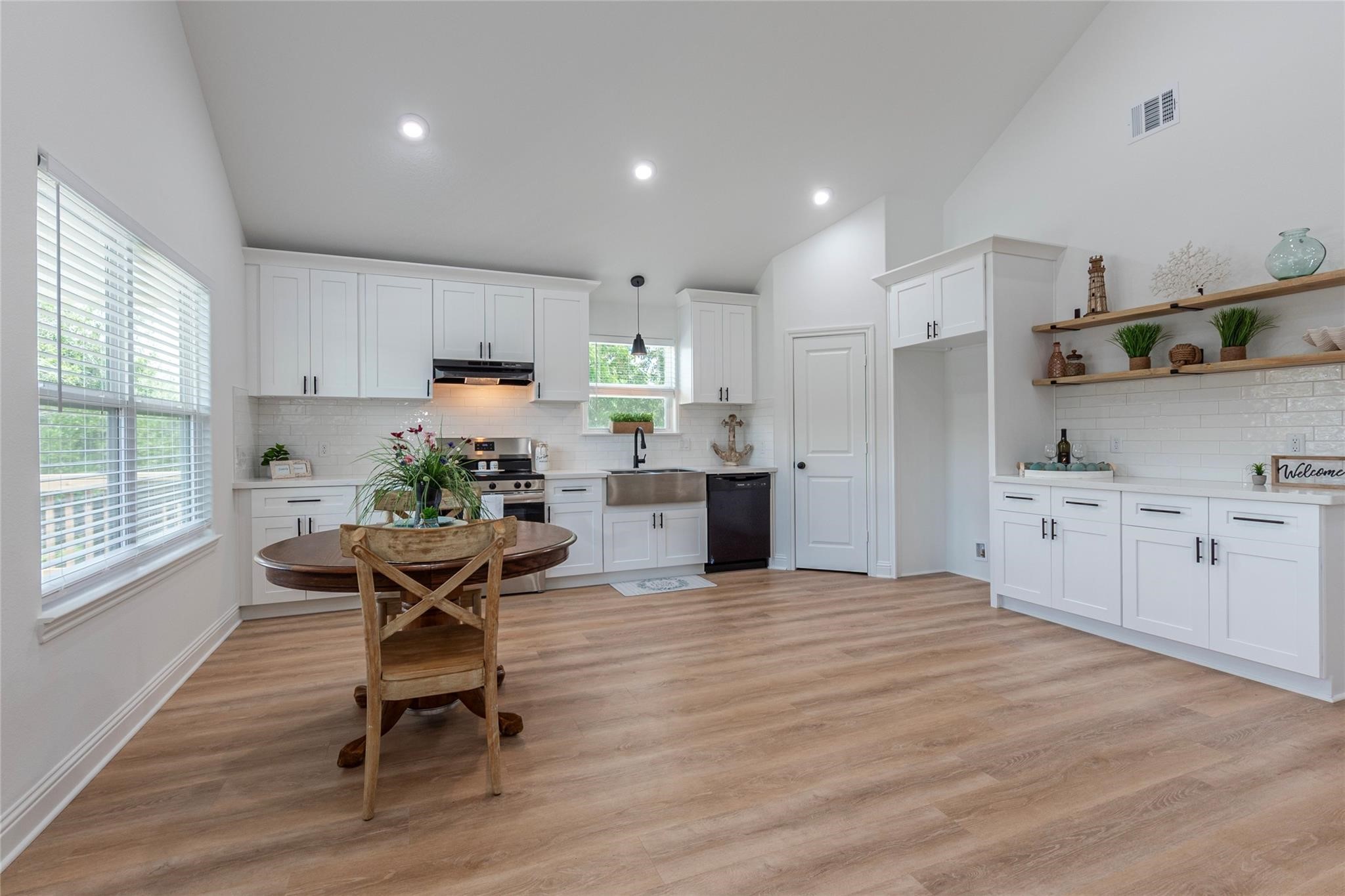 4213 Houx Street Bacliff, TX 77518 - Photo 7 of 37 a kitchen with stainless steel appliances kitchen island granite countertop a stove a sink a refrigerator and white cabinets with wooden floor