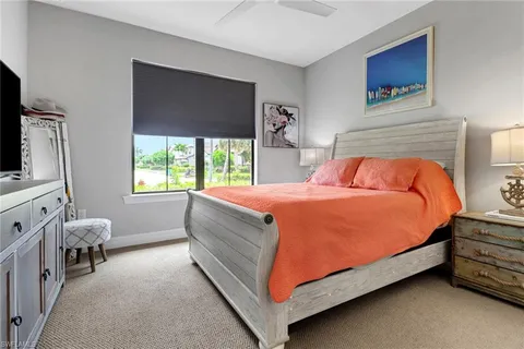 a bedroom with a bed and a flat tv screen on dresser