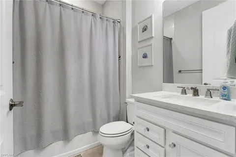 a bathroom with a granite countertop sink toilet and a mirror