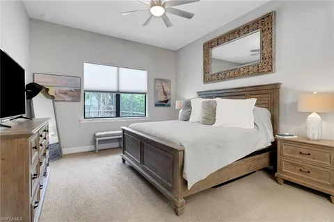 a bedroom with a bed and a flat tv screen on the dresser