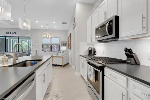 a kitchen with stainless steel appliances granite countertop a sink a stove and a microwave