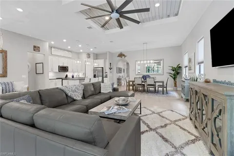 a living room with furniture kitchen view and a flat screen tv