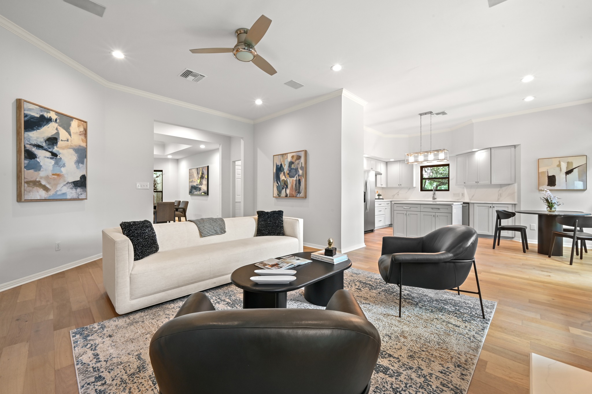 1107 Bowie Road Austin, TX 78733 - Photo 12 of 40 Soaring ceilings complement the open-concept living space, featuring a kitchen island and sleek hardwood flooring.